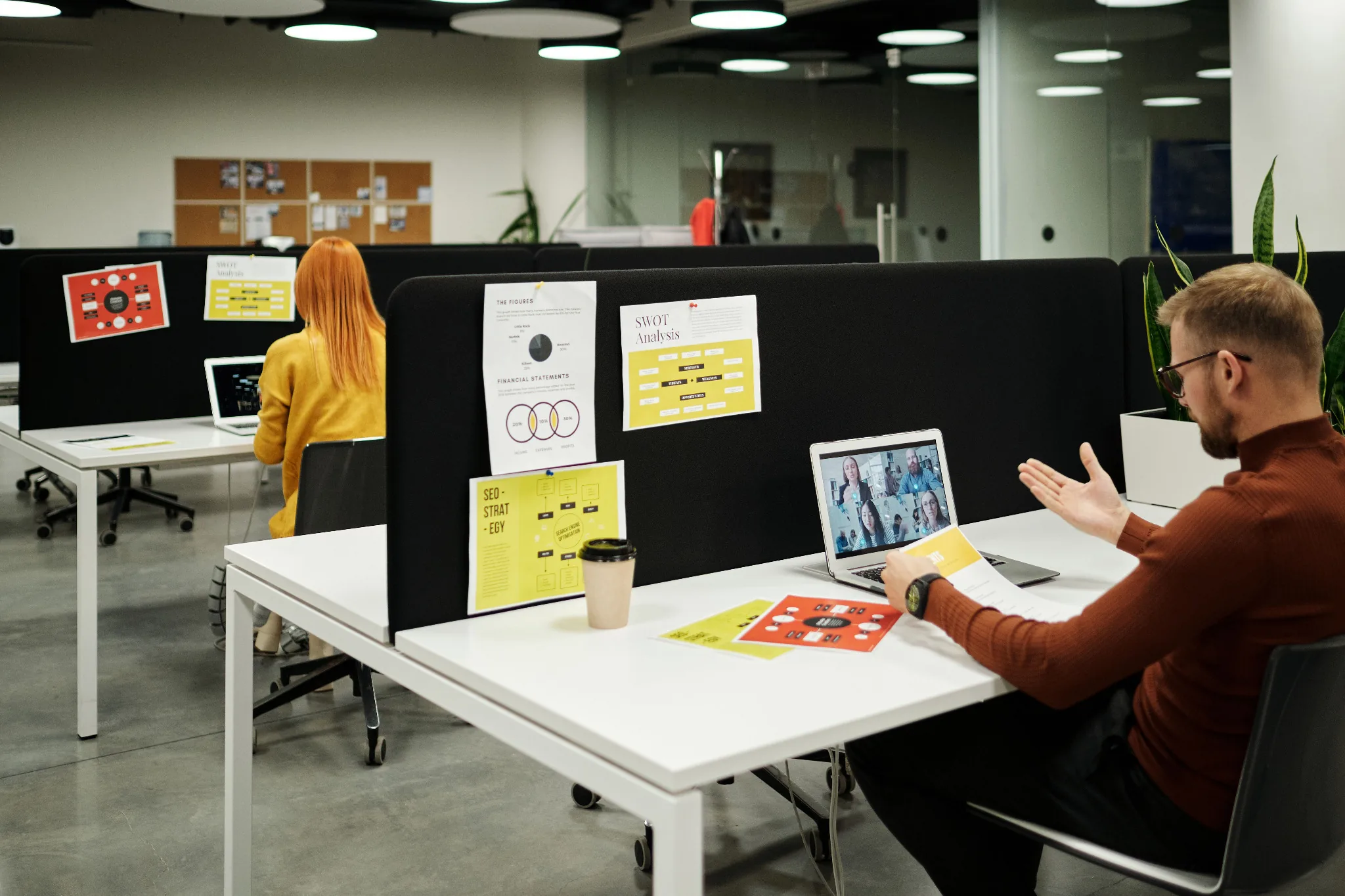 Professional speaking with colleagues on a video call from an office desk
